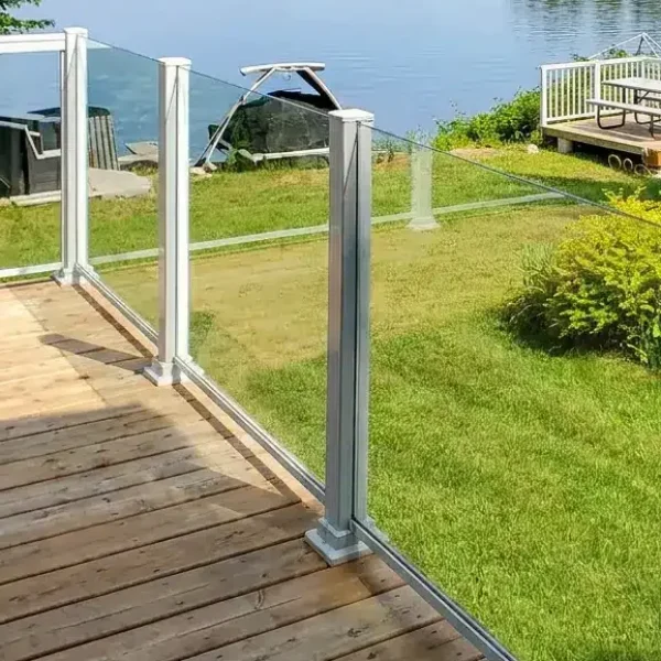 Terrasse résidentielle avec rampes en verre et aluminium offrant une vue dégagée sur la cour arrière.