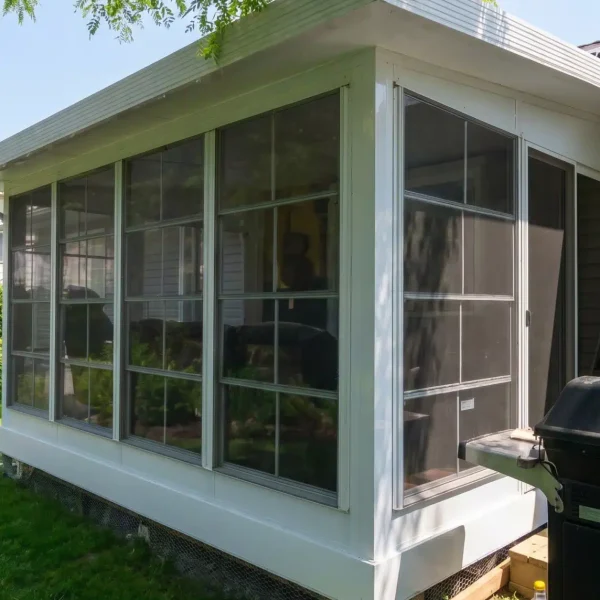Solarium 3 saisons en vinyle installé sur une résidence, prêt à être utilisé pendant la saison estivale.