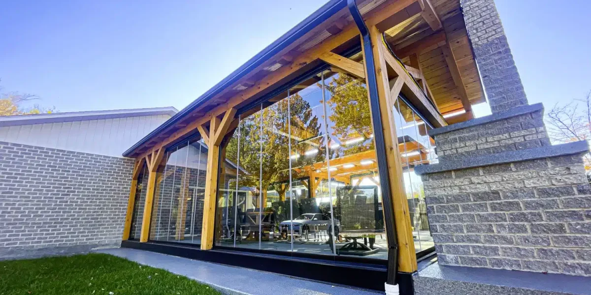 Patio fermé par des panneaux de verre Novasun Panoramic sous une structure en bois
